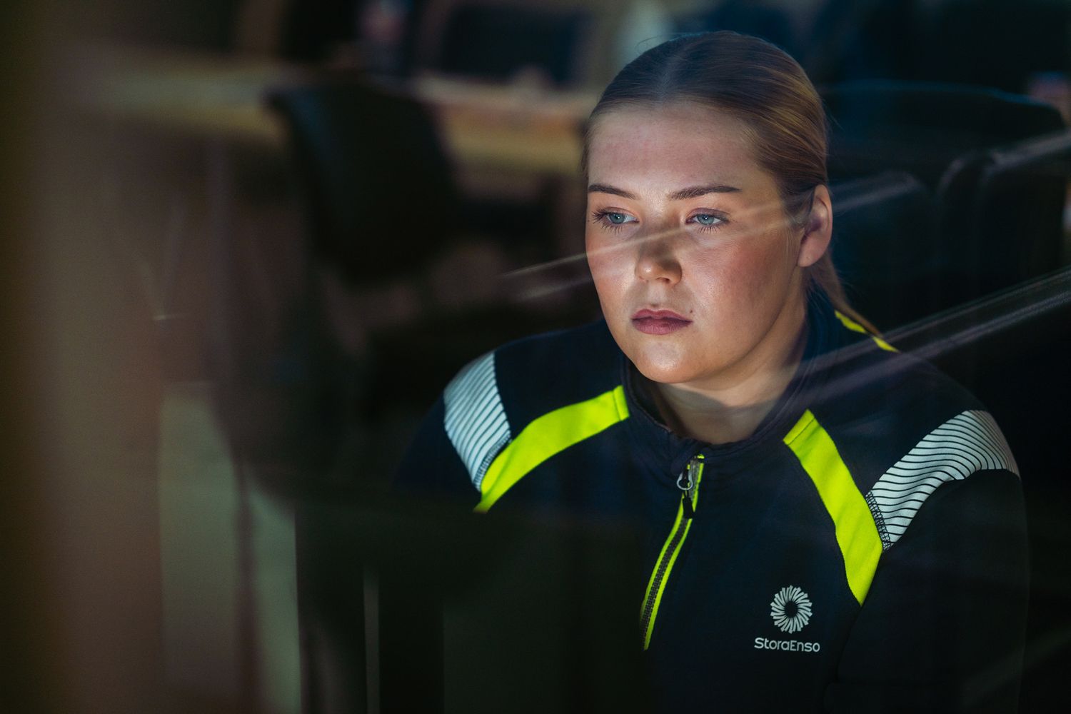 Kvinna som arbetar framför datorskärm på industri kontrollrum.