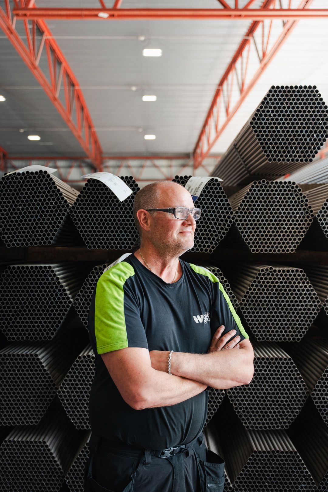 Porträtt i industrimiljö av man som tittar ut över arbetsplatsen. Porträttfoto av Gabriel Alenius