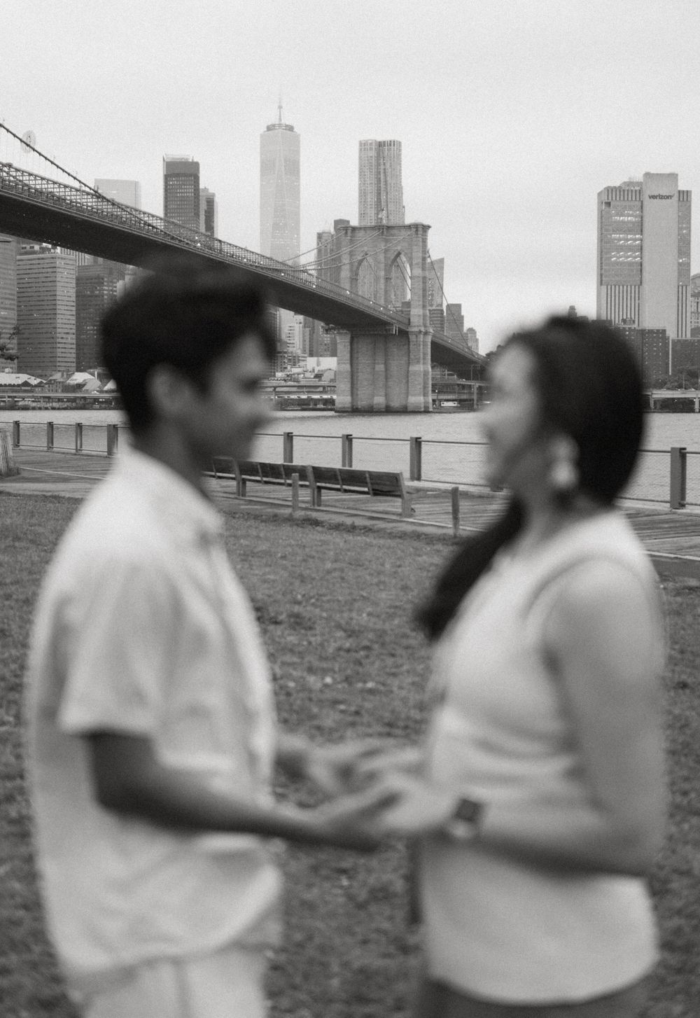 A sequence of black and white photographs showing two people interacting with the New York City skyline in background.