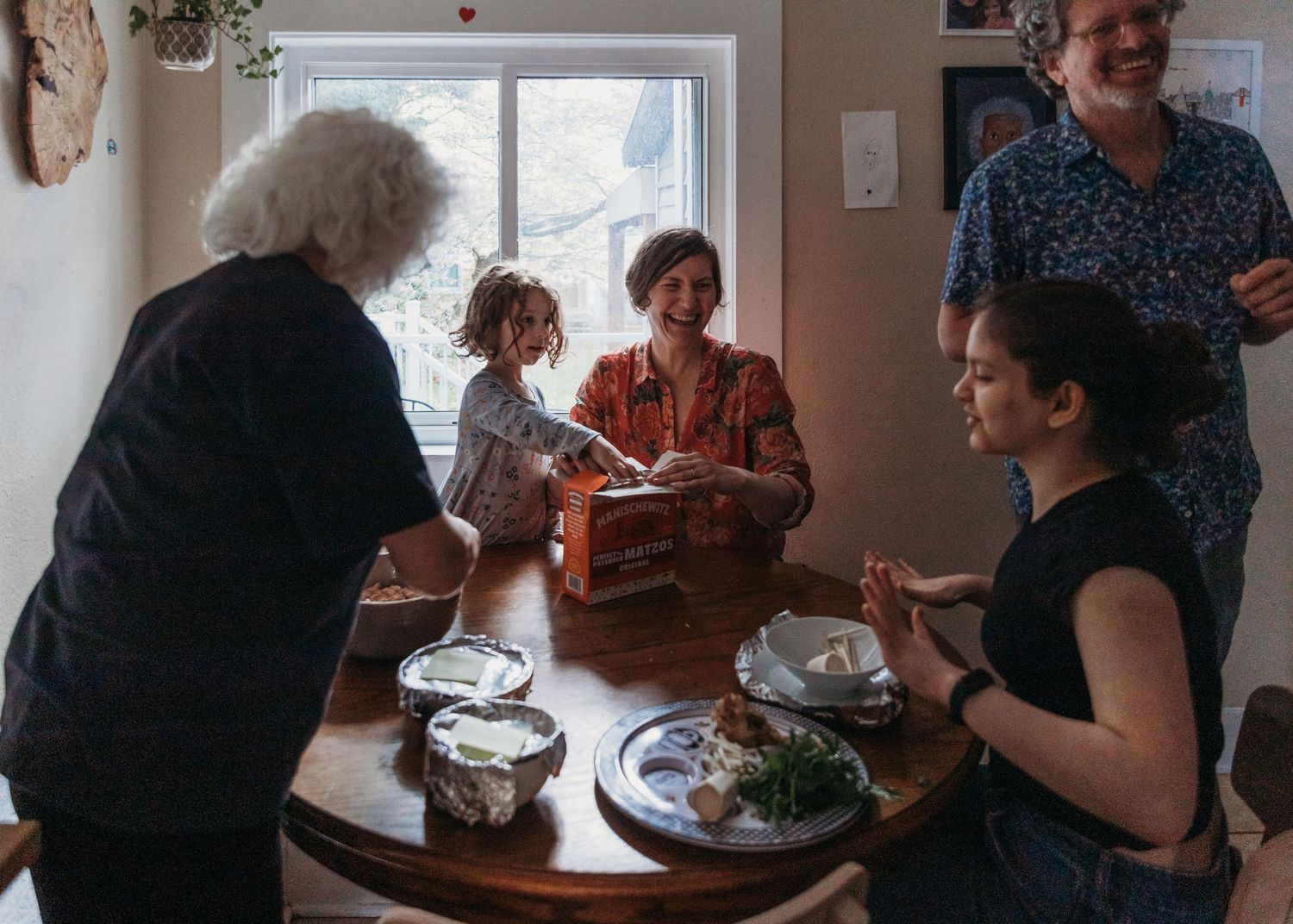 People gathered around a dining table enjoying a meal together in a bright interior space.