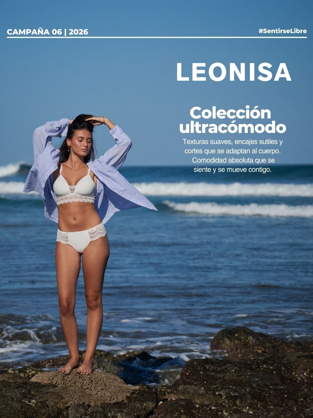 Woman in white lace lingerie set by Leonisa, lying on blue satin bedding with eyes closed.