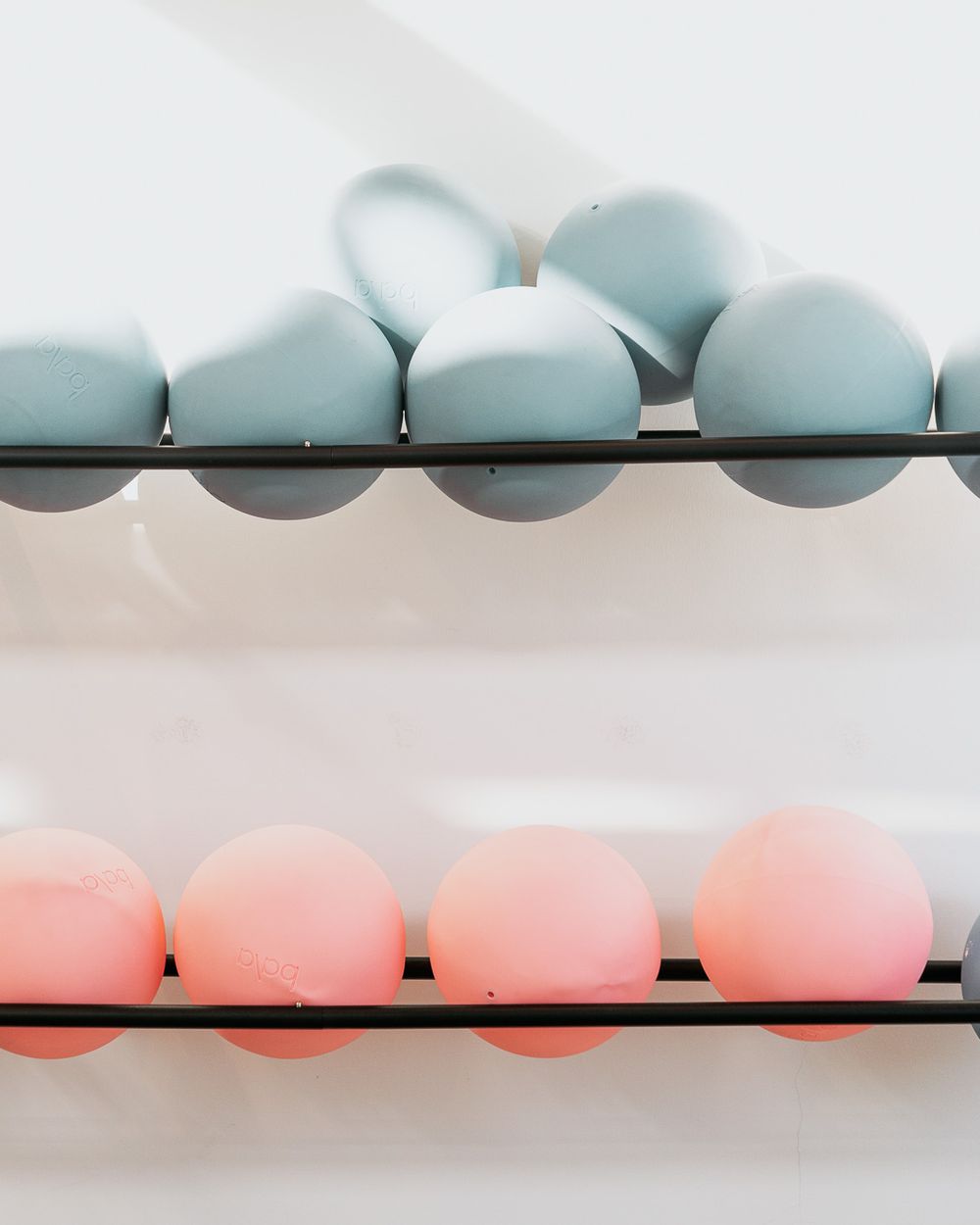 Two rows of pastel Easter eggs on metal racks, blue eggs on top and pink eggs on bottom.