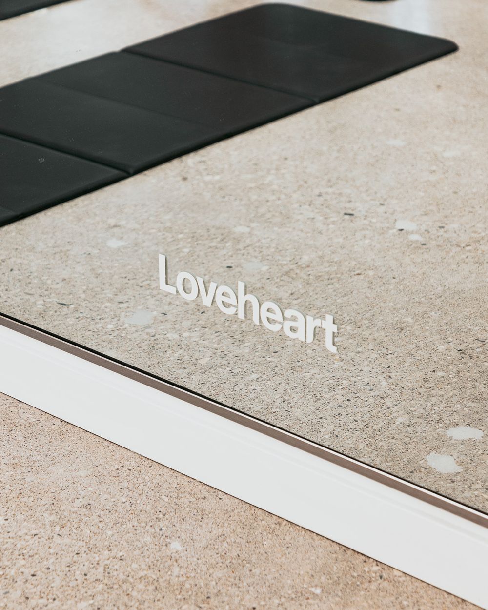 Loveheart signage displayed on mirror with yoga mat in frame