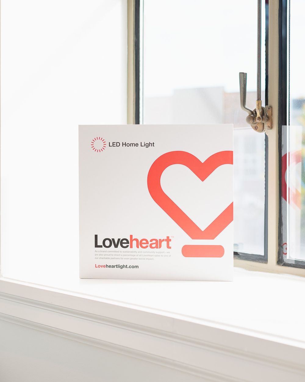 Loveheart LED Home Light product box displayed on a white windowsill with a heart logo design.