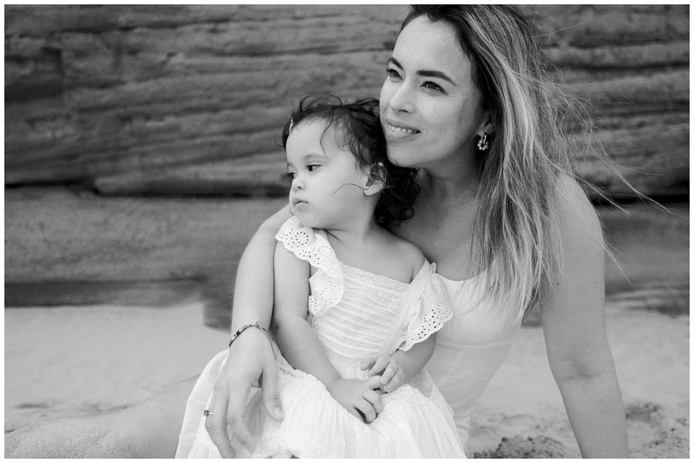 A series of black and white photographs showing tender moments between a parent and child in an outdoor setting.
