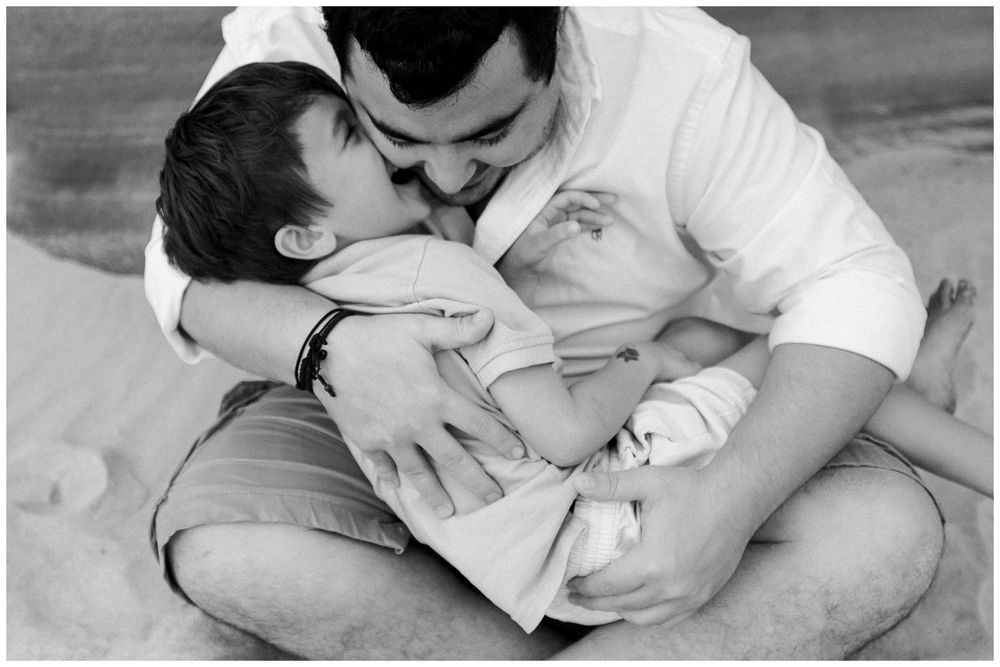 A series of tender black and white photographs showing intimate moments between parent and newborn baby.
