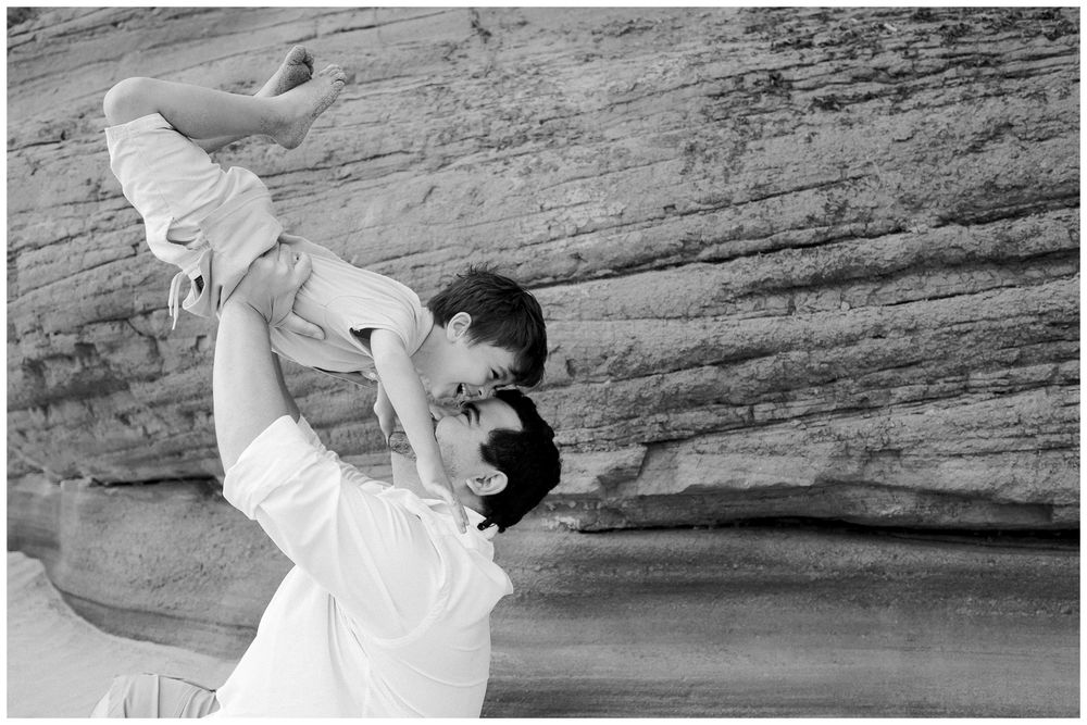 A tender black and white moment captured against a rocky backdrop showing playful interaction and joy.