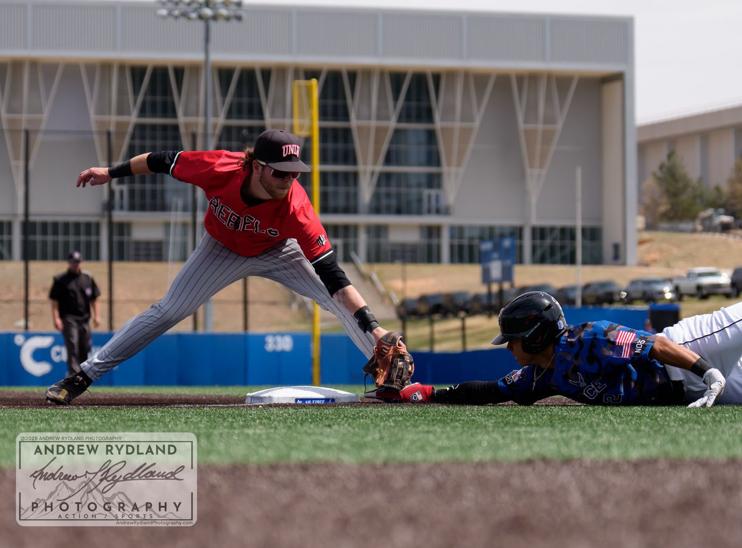 Baseball player slides into base during competitive game as opponent attempts to make the tag.