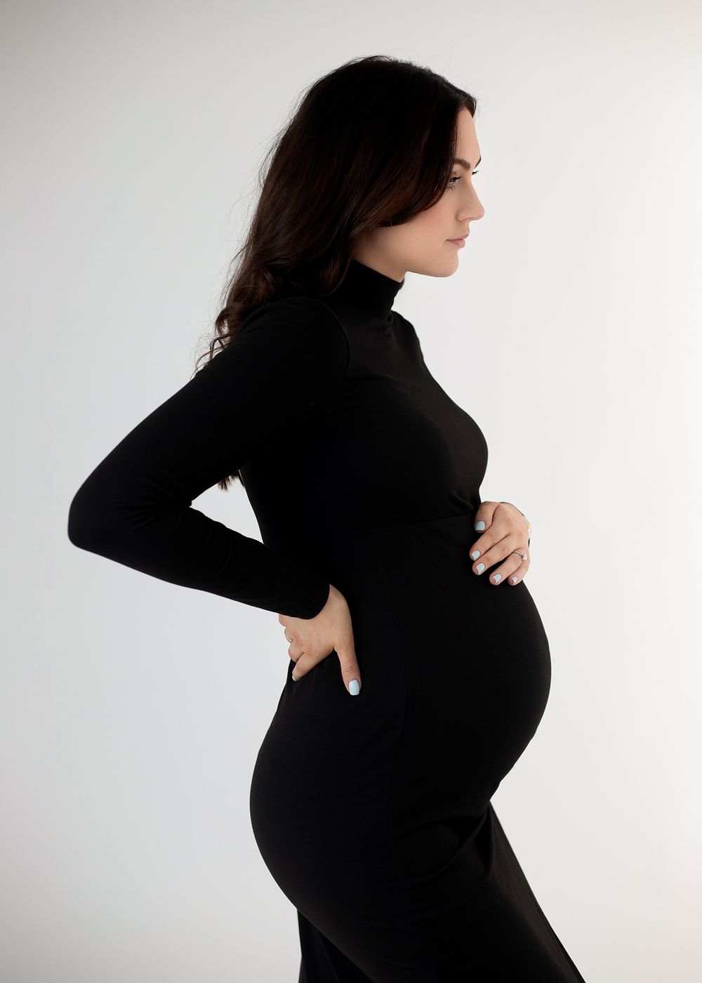 A series of profile views showing the progression of a pregnancy silhouetted against a white background.