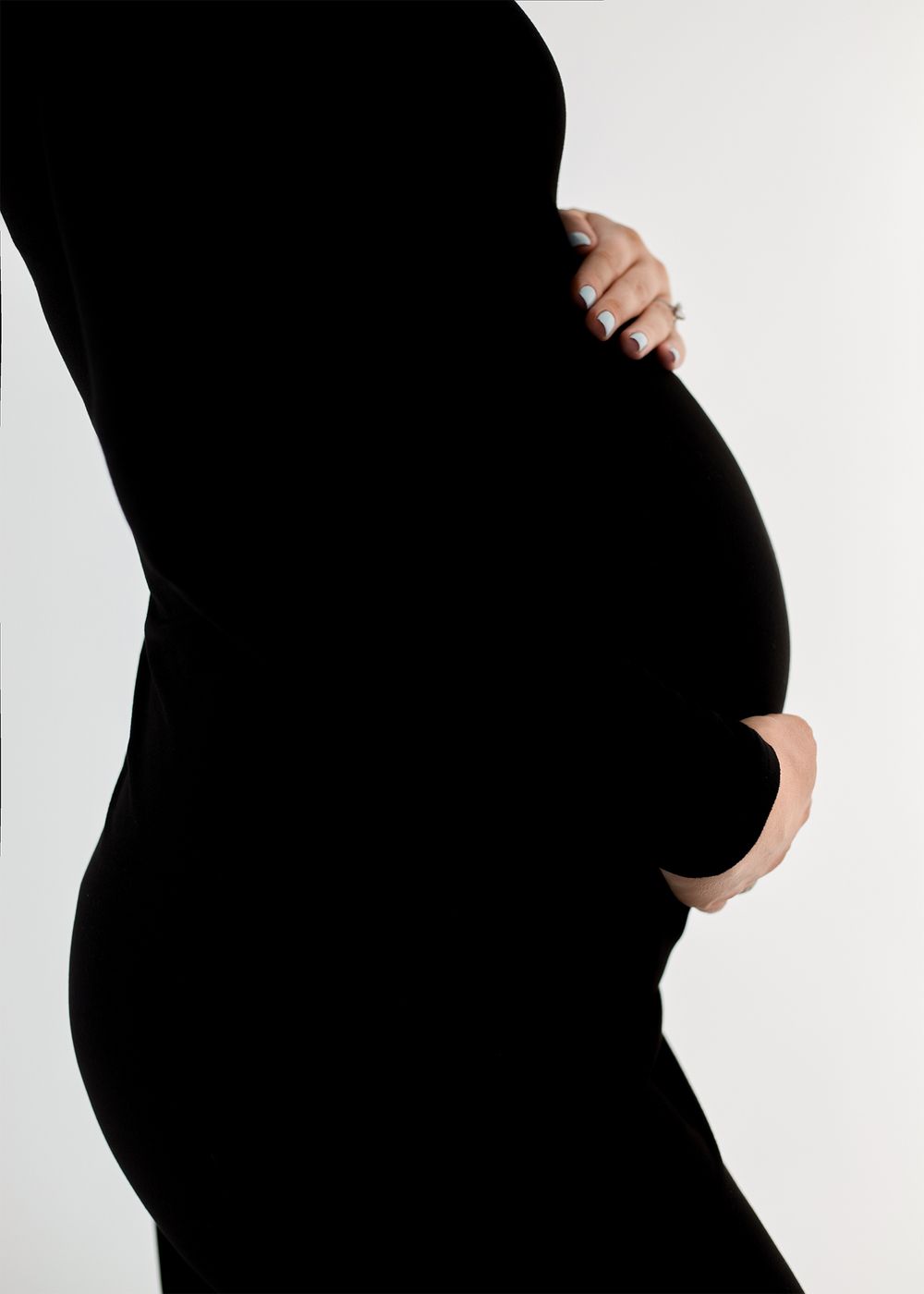 A series of black and white silhouette photos showing a pregnant woman's growing belly from different angles.