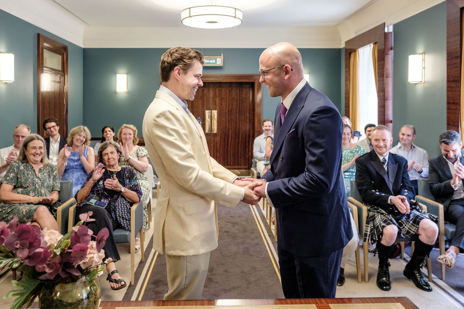 A bride and groom standing together and smiling on their wedding day.