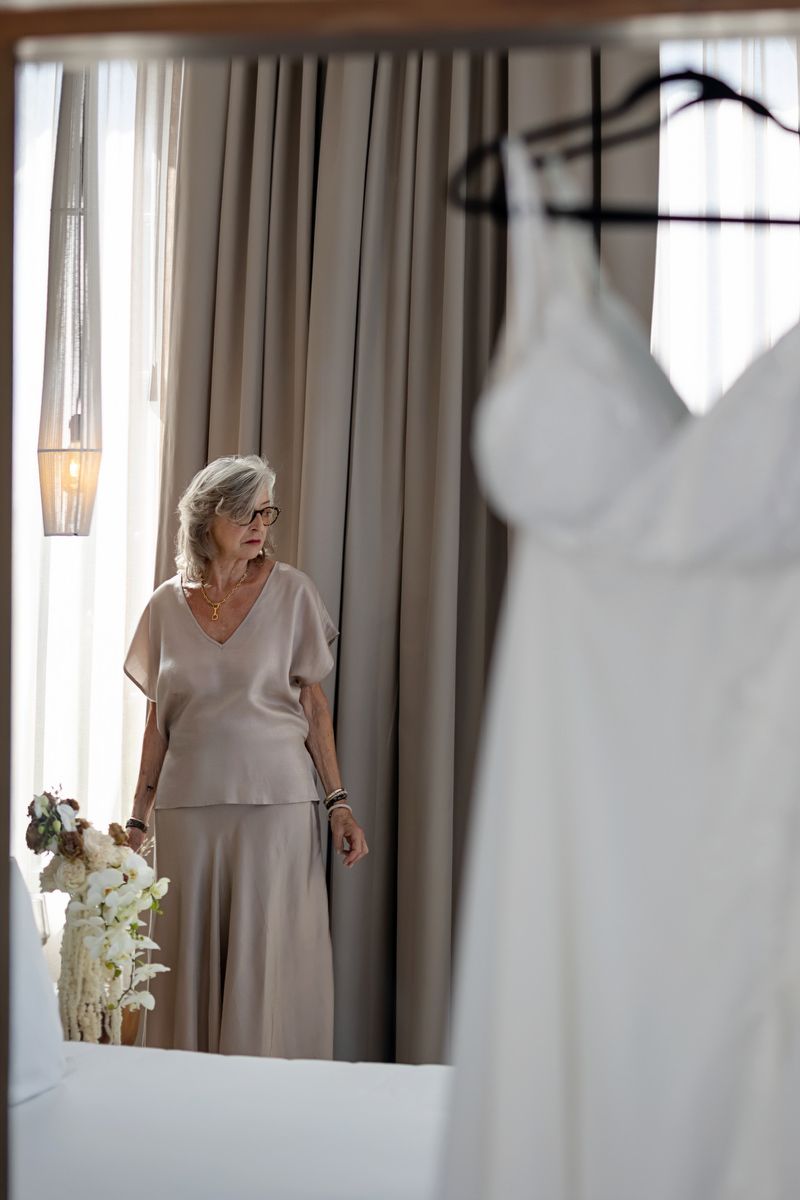 Emotional moment of bride’s mother looking at wedding dress during getting ready in Tulum destination wedding.