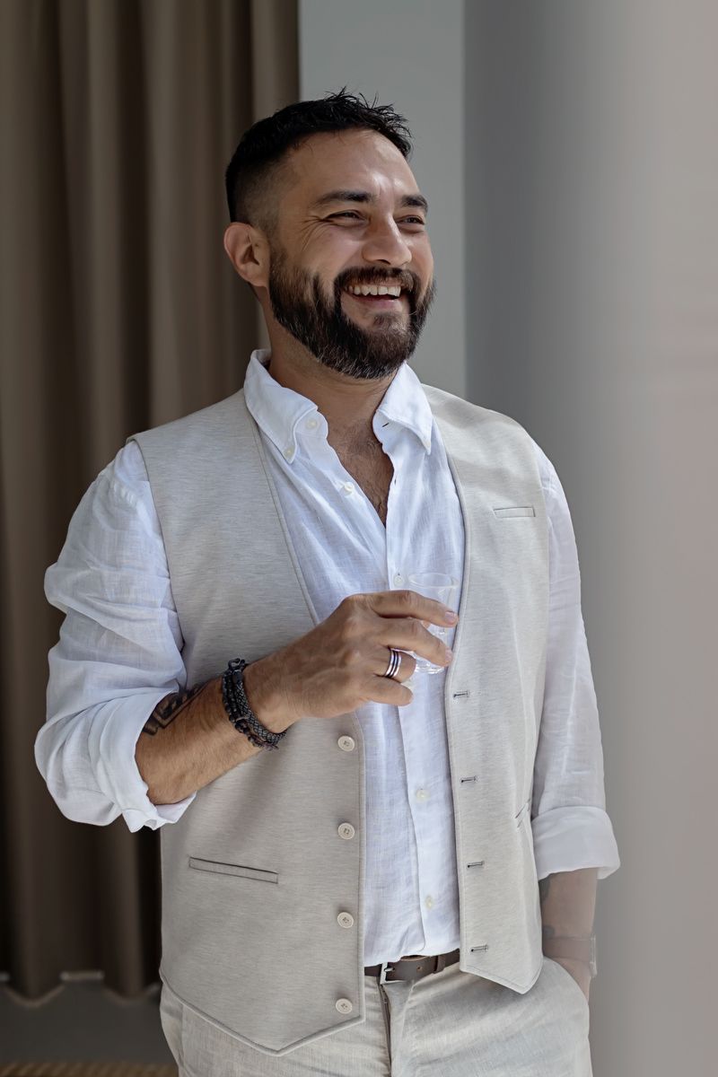 Groom smiling during getting ready in Tulum destination wedding, wearing light linen suit at Studio 54 villa.