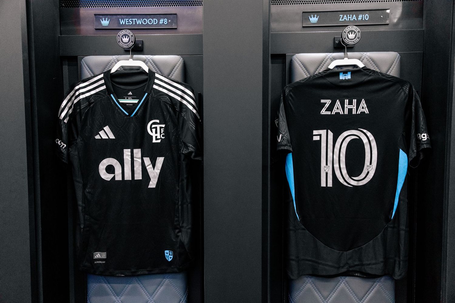 Charlotte FC Fortress Kit jerseys for Westwood and Zaha hanging in the team locker room.