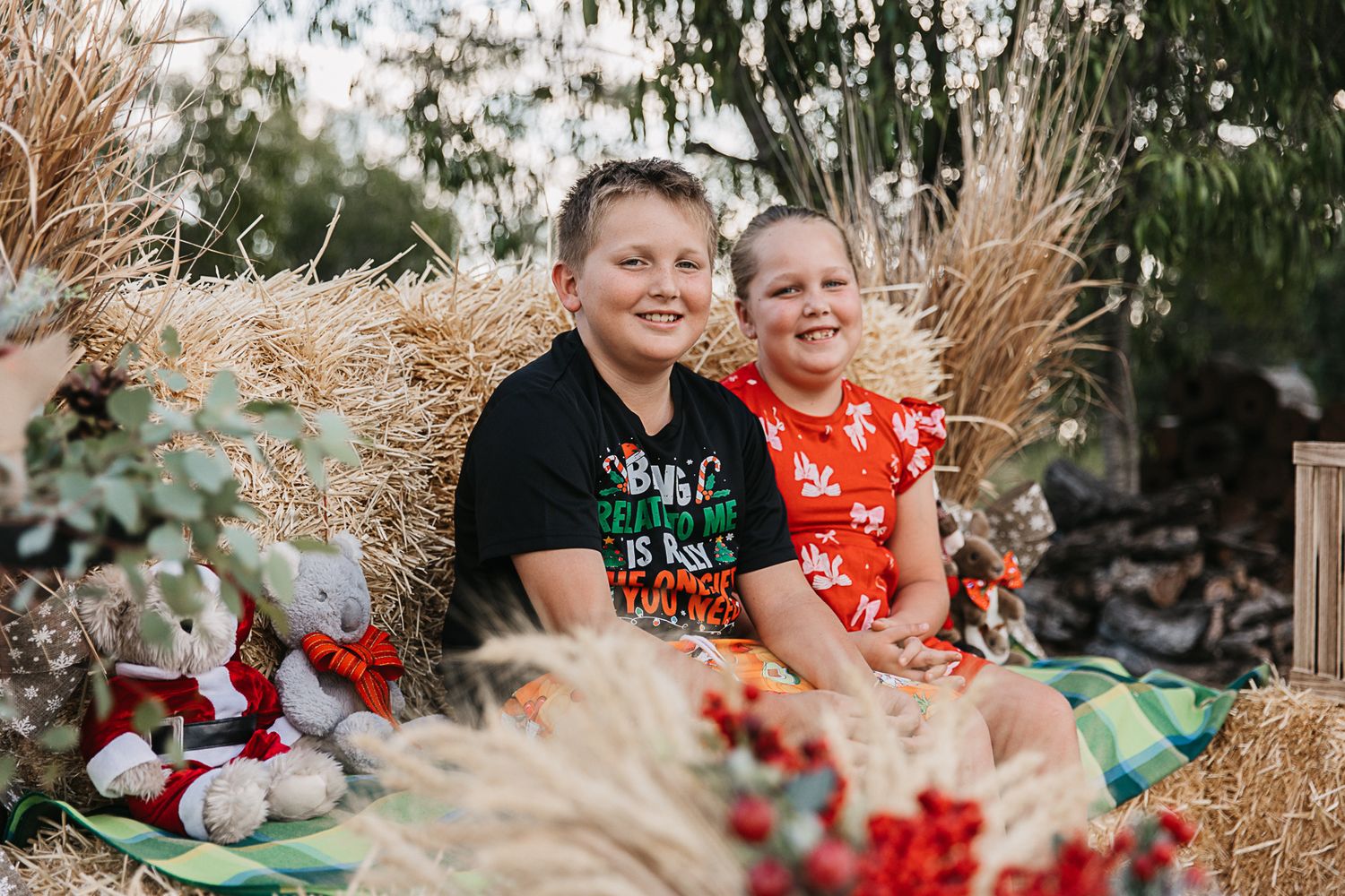 family sitting on hay bales at country, rustic christmas mini photo shoot