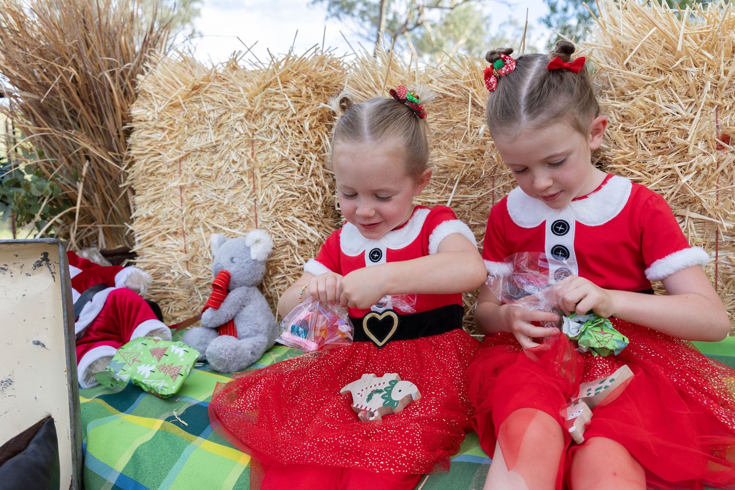 family sitting on hay bales at country, rustic christmas mini photo shoot
