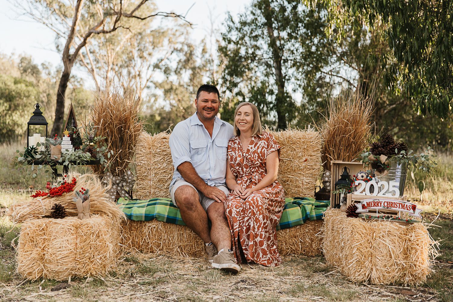 family sitting on hay bales at country, rustic christmas mini photo shoot