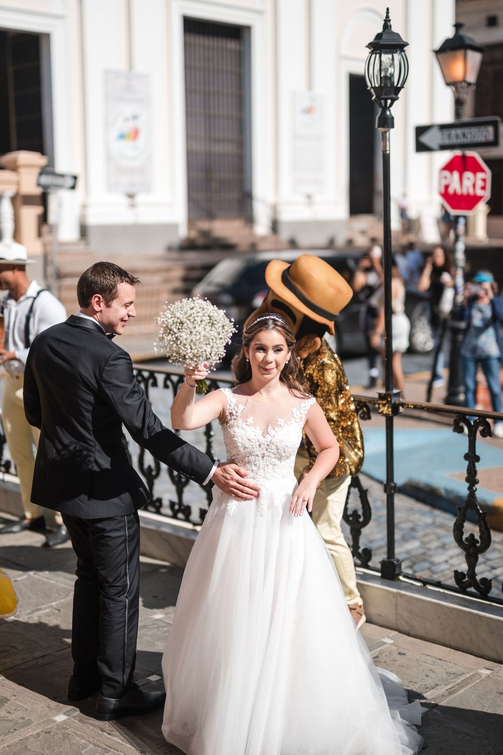 Bride and groom pausing together during wedding parade in historic Old San Juan streets
these