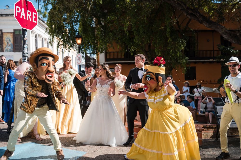 Bride and groom dancing with vejigante performers during traditional Puerto Rico wedding parade