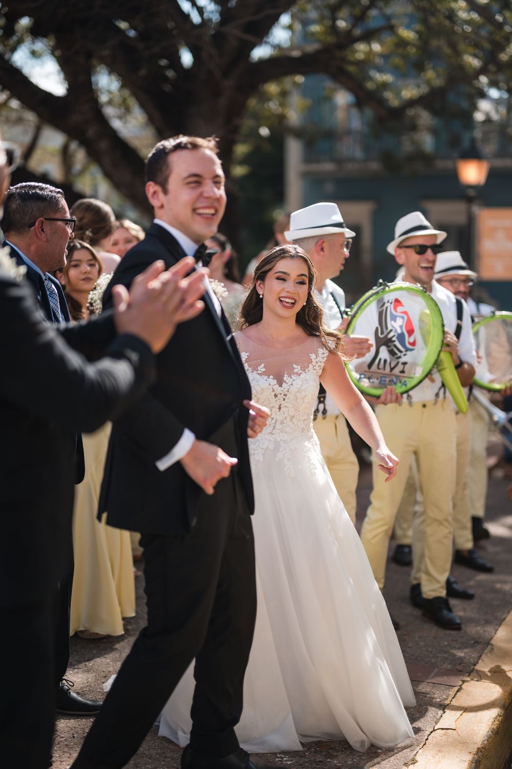 Bride and groom walking with live band during wedding parade in Old San Juan Puerto Rico