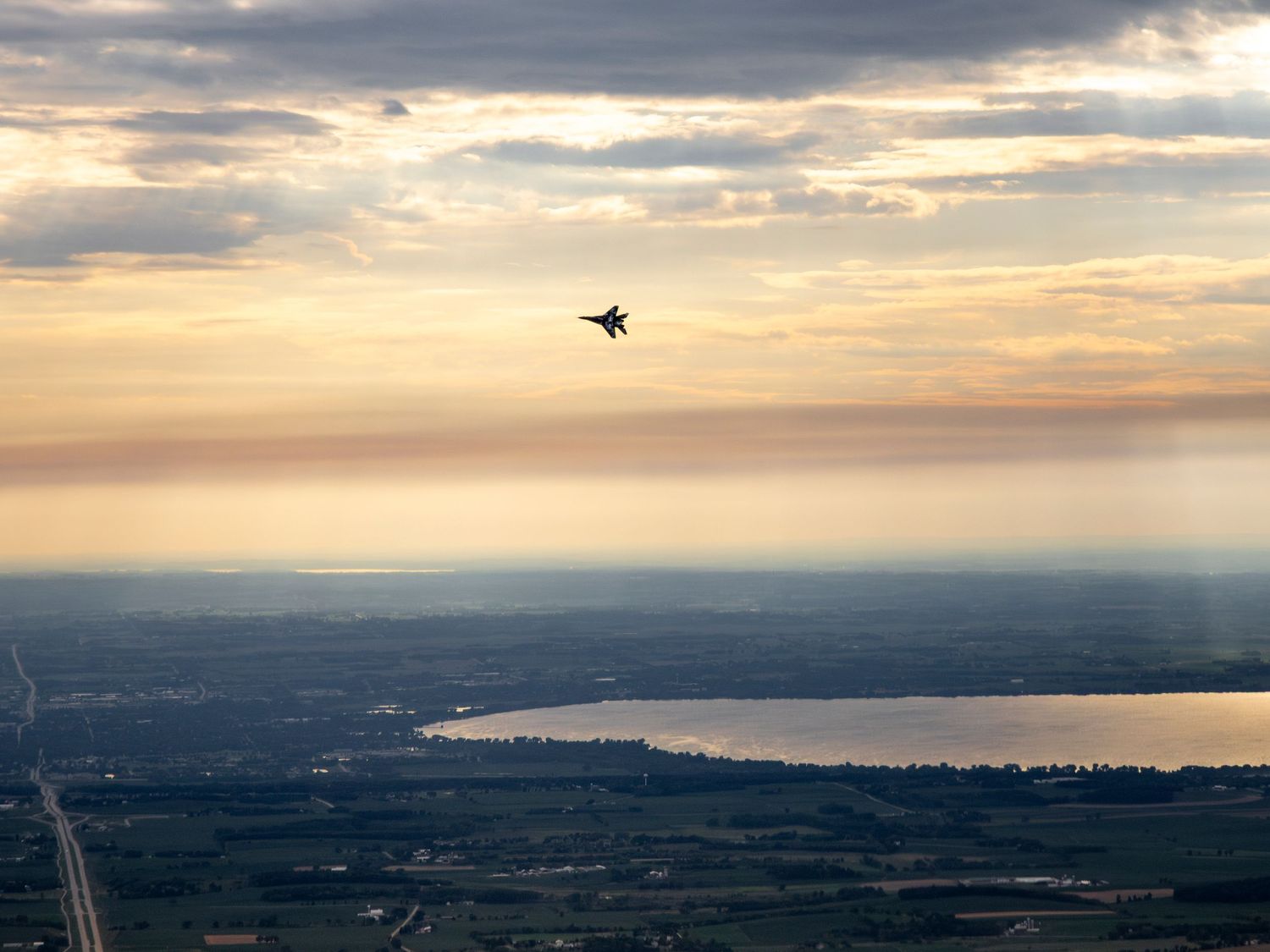 A MiG-29 Flying just before sunset above a spectacular midwest landscape