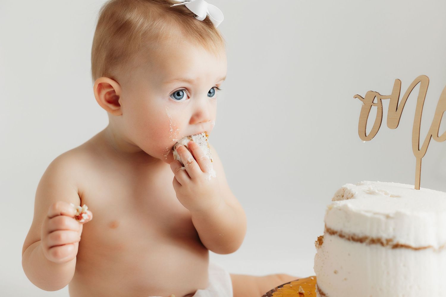 Baby feeding herself cake. Greenville sc newborn photographer, Easley sc newborn photographer, Upstate newborn photographer.