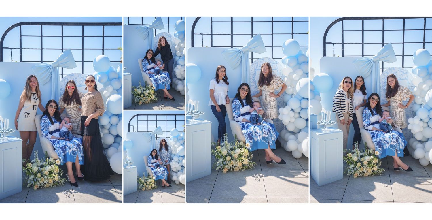 A group poses together against a blue wall with arched windows and yellow flowers in a casual outdoor photo session.