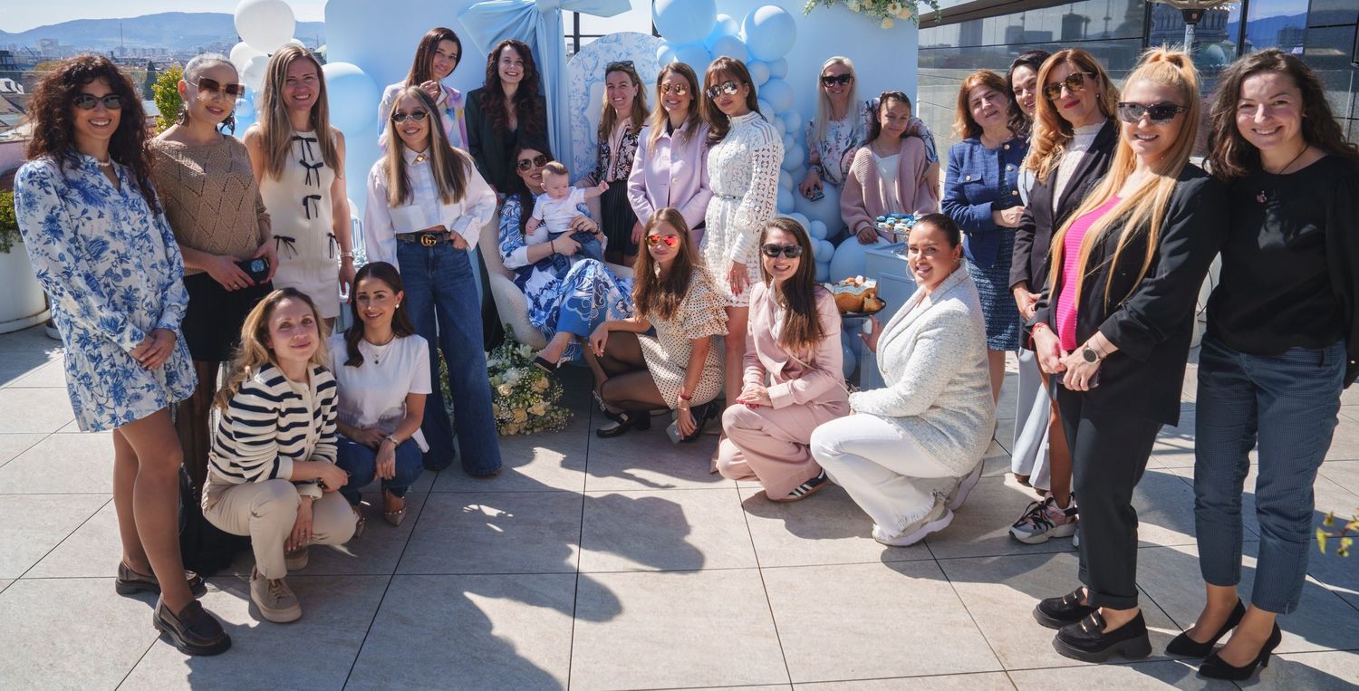 People mingle and socialize at an outdoor gathering with blue decor and casual atmosphere.