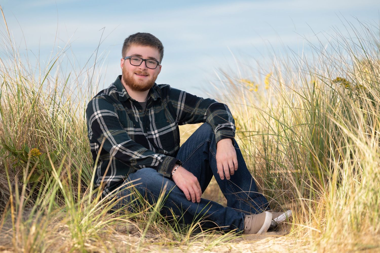 A figure sits among tall golden grass at sunset, creating a serene outdoor portrait series.