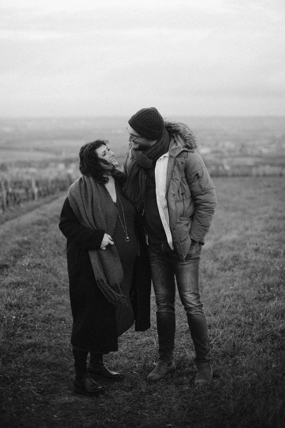 A vintage black and white photo sequence showing a couple in a romantic interaction on a hillside landscape.