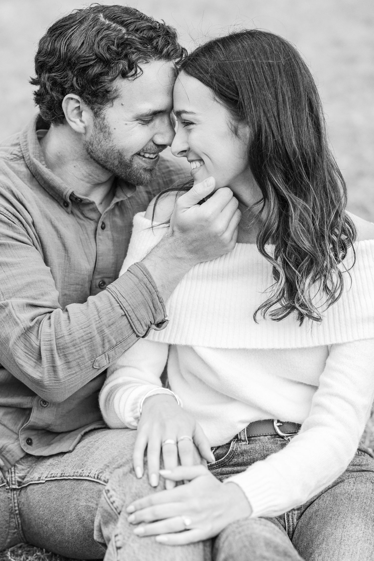 A romantic black and white photo series showing a couple in casual clothing sharing intimate moments together.