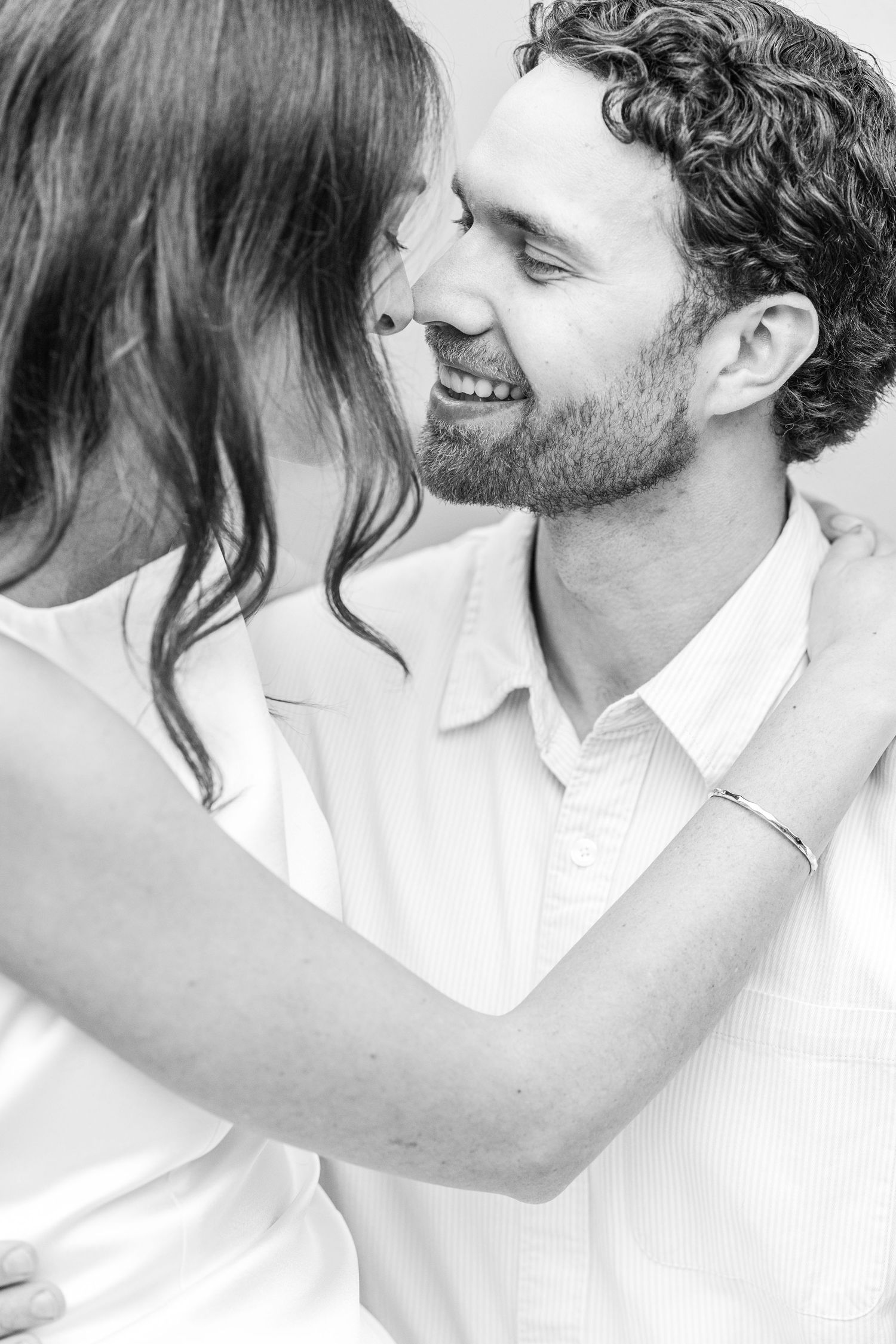 A romantic black and white photo series showing an intimate moment between two people in white shirts.