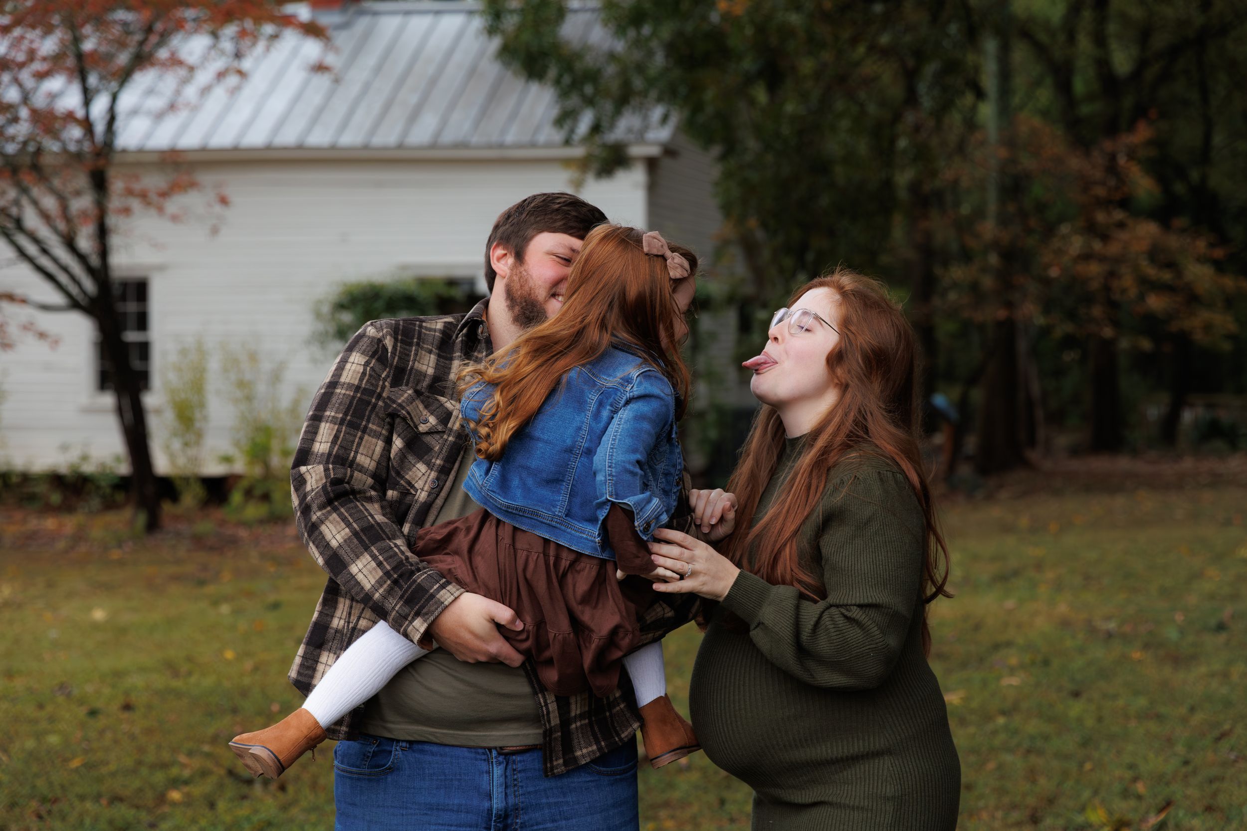 A couple embraces in a romantic outdoor photoshoot wearing casual fall clothing.