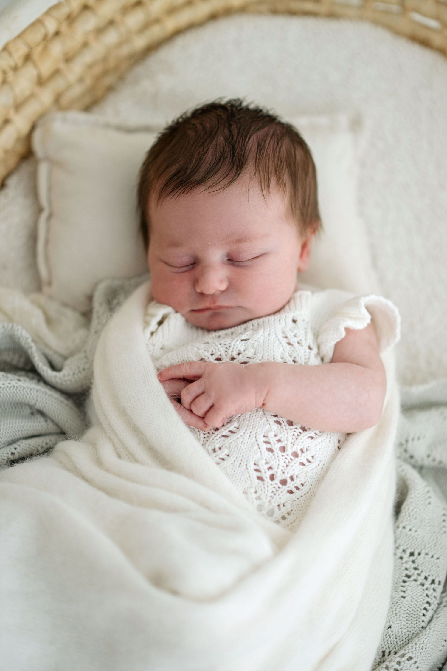 Sleeping newborn baby wrapped in soft white lace blanket shown from multiple angles in peaceful slumber.