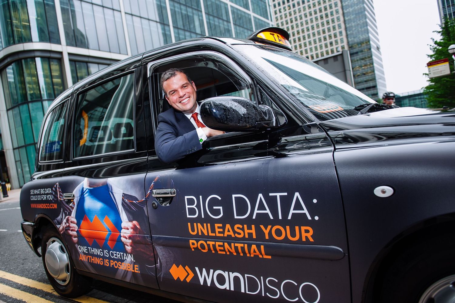 Taxi driver in London black cab advertising Big Data services.