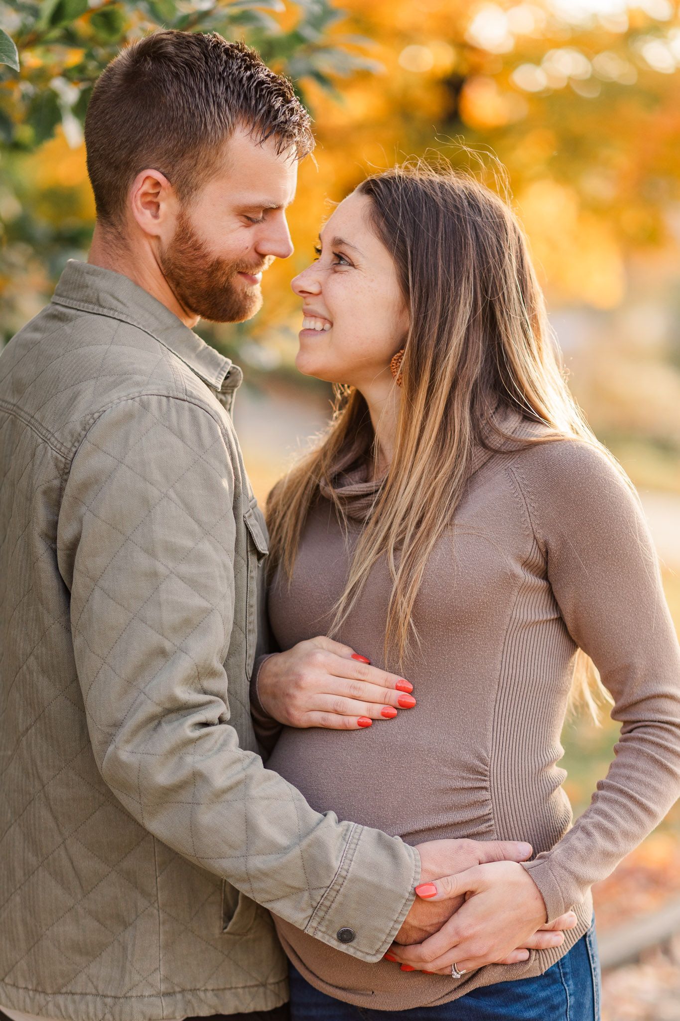Maternity photo session with husband and wife smiling at each other on Libby Hill in Richmond Virginia