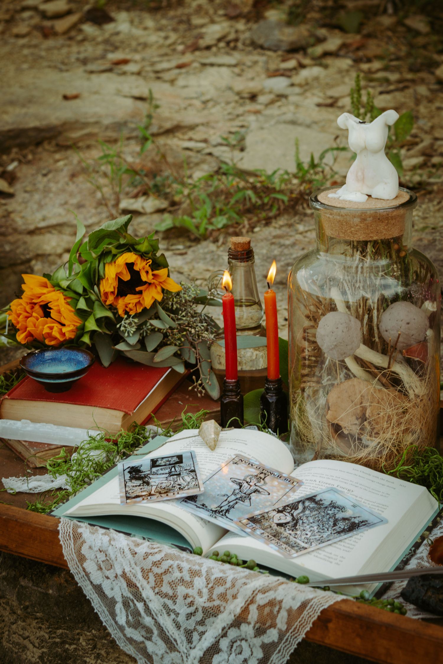 Vintage books and sunflowers arranged on a table with candles and lace decorations.
