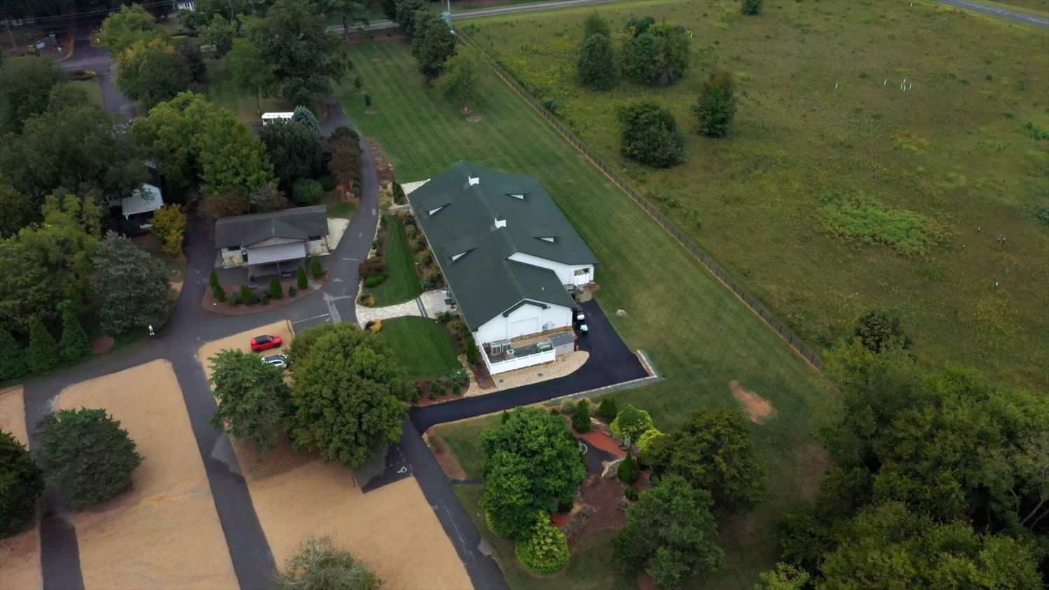 Aerial view of property with buildings and trees surrounded by brown floodwater.