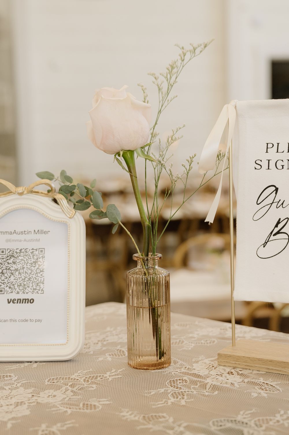 Wedding reception table details with delicate floral arrangements and QR code place cards.