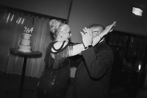 Black and white photo of a dimly lit wedding reception dance floor.