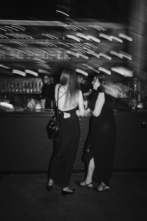 Low-angle black and white shot of people dancing at a wedding reception.