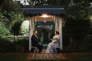 Romantic outdoor wedding portraits captured in a garden setting at dusk.