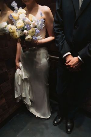 Wedding ceremony scene with white dress and floral bouquet details.