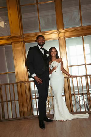 Couple shares romantic dance moment in wood-paneled ballroom.
