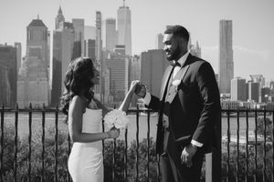 Black and white portrait of couple with Manhattan skyline in background.