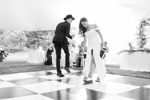 Black and white photo of people playing on a large outdoor checkerboard.
