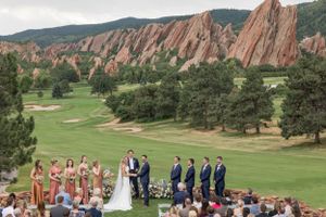 Outdoor wedding ceremony setup with red rock formations and mountain landscape in the background.