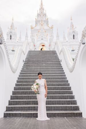 Grand white temple staircase with ornate architectural details creates a dramatic wedding setting.