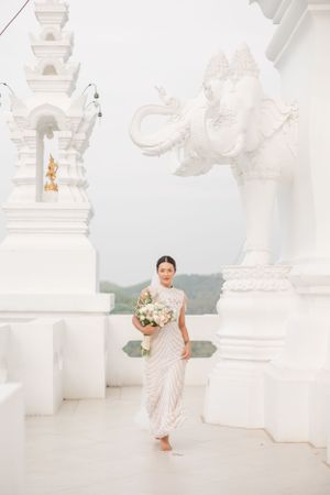 Elegant white temple architecture with ornate details forms a stunning wedding backdrop.