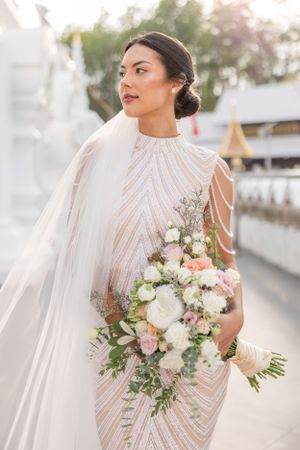 Wedding portraits featuring an elegant high-neck beaded gown with floral bouquet.